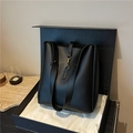 Elegante bolso de cubo en cuero negro con cierre de latón y correa ancha ajustable - Negro