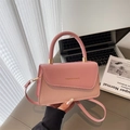 Bolso bandolera rosa con patrón de cuero tejido y asa dorada en ambiente de oficina chic - Rosa
