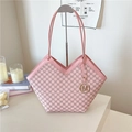 Pink monogram tote bag with leather trim and gold hardware in a chic lifestyle setting - Pink