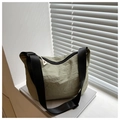 Detail of light olive nylon crescent bag with wide black strap on minimalist windowsill - Green