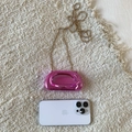Vista dettagliata della pochette in acrilico rosa metallizzato con catena dorata e manico - Rosa