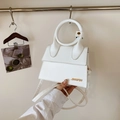 Weiße minimalistische Henkeltasche mit rundem Griff und goldfarbenem Metall-Logo-Detail - Cremeweiß