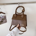 Dunkelbraune Handtasche mit rundem Goldgriff und eleganter Kunstleder-Oberfläche - Braun