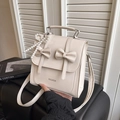 Cream butterfly mini backpack with pearl charm and fashion logo in a hand-held view - With Pendant / White