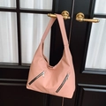 Bolso tote rosa de cuero granulado con cremalleras plateadas colgado de una puerta negra - Rosa Loto
