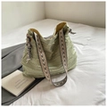 Detail of light green canvas tote bag featuring frayed layers and geometric strap - Green