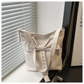 Vista dettagliata della borsa tote bianca con fiocco decorativo e borchie argentate - Bianco Sporco