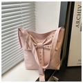 Dettaglio della borsa tote rosa con fiocco decorativo e accenti di borchie metalliche - Rosa
