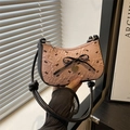 Bolso hobo rosa con lazos negros y colgante de corazón dorado en escena moderna - Rosa