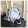 Détail du sac seau bleu clair à fleurs avec cordon de serrage et bandoulière tissée - Bleu