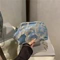 Borsa a secchiello in raso blu con ricami floreali dorati e tracolla a catena - Blu