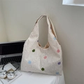 Borsa tote bianca pelosa a pois colorati su una scrivania con laptop e libri - Punti Colorati