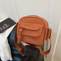 Orange-brown corduroy crossbody bag with woven rope zipper detail and wide shoulder strap - Brown