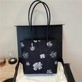 Bolso tote negro con flores blancas y asas delgadas en una caja de regalo negra - Negro