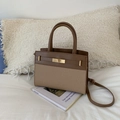 Chic two-tone brown leather and woven texture crossbody bag on a white bed - Brown