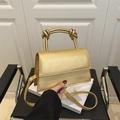 Chic metallic gold handbag with a unique knot handle and crossbody strap for women - Gold