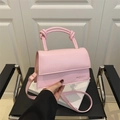 Chic pink handbag with a knotted handle and adjustable strap for shoulder or crossbody use - Pink