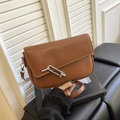 Borsa a sella in ecopelle marrone con chiusura a alamaro argento e tracolla sottile - Marrone
