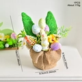 Oster-Tischdeko mit grünen Strohhasenohren und bunten gesprenkelten Ostereiern - Simulation Ei Ornament Stil