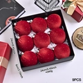 Detail of nine red velvet Christmas balls with silver glitter in a black gift box - Red