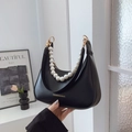 Fashionable black hobo bag with pearl chain and adjustable leather strap in lifestyle setting - Black