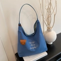 Blue canvas tote bag with elegant embroidery and brown leather charm for daily use - Blue