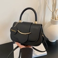 Elegante borsa a tracolla nera con hardware dorato e ciondolo moda in un ambiente chic - Nero