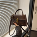 Elegante dunkelbraune Lackleder-Handtasche mit goldenem Metallschloss und Trageriemen - Braun