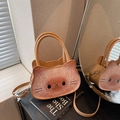 Close-up of cat-shaped bread bag on a book with dual handles and crossbody strap - Khaki