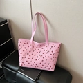 Roze tote bag met kersenprint en lederen handvatten met gouden studs op een bankje - Roze