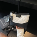 Black and white quilted crossbody bag with fashionable wide strap on minimalist desk - Off-white