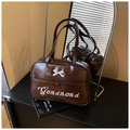 Detail of dark brown patent leather tote bag featuring a 3D white bow and embroidery - Brown