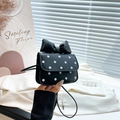 Mini crossbody bag with black polka dots and a large bow detail shown in hand - Black