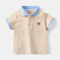 Detail eines hellorangen Jungen-Poloshirts mit blauem Kragen und Cartoon-Hundestickerei - 90cm / Aprikose