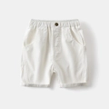 Detail of boys white cotton casual shorts showing elastic waist and metal button - White / 90cm