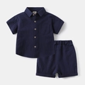 Flat lay of dark blue cotton linen kids set showing shirt pocket and elastic shorts - Navy Blue Set