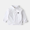 Nahaufnahme des weißen Baumwoll-Poloshirts für Kleinkinder mit Schirmstickerei - Weiß