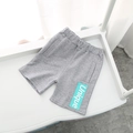 Detail of grey knitted boys' shorts featuring an elastic waistband and Unique patch - Gray / 90cm