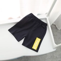 Detail of boys' summer shorts featuring a yellow 'Unique' text print on soft knit fabric - Navy Blue / 90cm