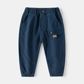 Detail of navy cotton kids joggers featuring elastic waist and utility pocket with THE tag - Size 90 / Dark Navy Blue