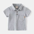 Dettaglio polo grigia da bambino con taschino sul petto, etichetta in pelle e bottoni - 100cm / Grigio