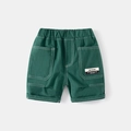 Detailed close-up of dark green boy's cargo shorts with elastic waist and woven label - Dark Green / 90cm