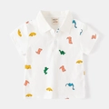 Detail view of children's white polo shirt featuring colorful dinosaur cartoon print patterns - 120cm / White Dinosaur