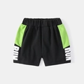 Detail van elastische tailleband en RUN-print op zwarte en neongroene sportshort voor kids - 90cm / Zwart