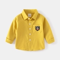 Dettaglio camicia in cotone giallo zenzero con taschino ricamato orsetto e bottoni bianchi - 90cm / Giallo