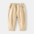 Detalle de la cintura elástica y la etiqueta en pantalones casuales caqui para niños - Caqui / 90cm