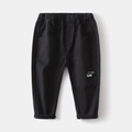 Detail of kids black casual cotton pants featuring elastic waist and letter patch print - Black / 90cm
