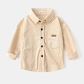 Primer plano detallado de camisa infantil de pana beige con botones y bolsillo frontal - 110cm / Albaricoque