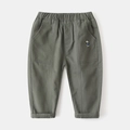Dettaglio dei pantaloni per bambini verde militare con vita elastica e ricamo a orso - 90cm / Verde Militare
