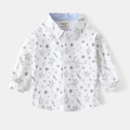 Dettaglio di una camicia in cotone bianco con stampa a stelle e etichetta sul collo - 90cm / Bianco (Stampa All-over)